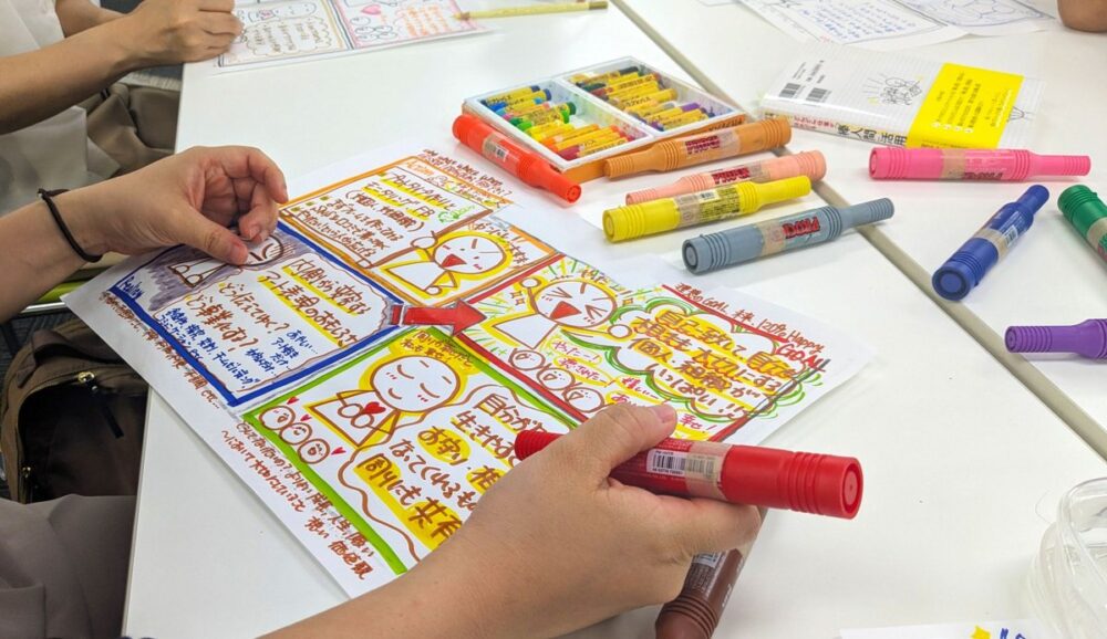 参加者が、カラーのペンで、4コマのイラストを描いている手元